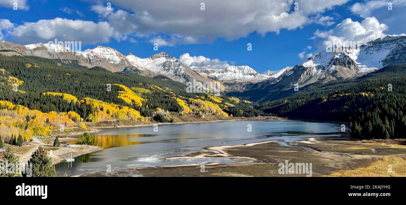 Un'ampia scelta di lago di trota, la foresta nazionale di San Juan, circondata da una foresta colorata in tonalità autunnali, con cime innevate sullo sfondo e cielo Foto Stock