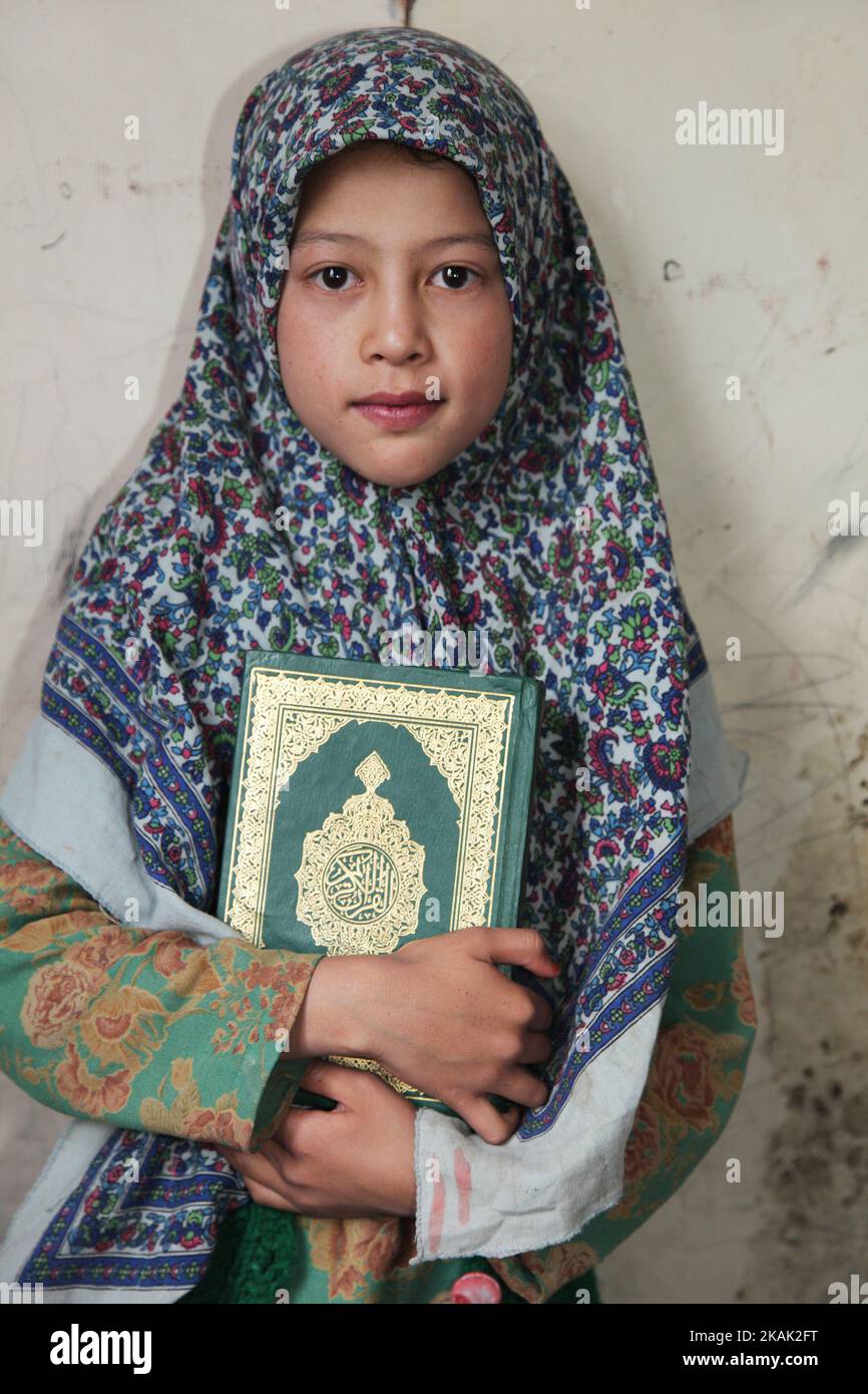 Ragazza musulmana che tiene il Corano in una Madrasa (scuola religiosa islamica) in un piccolo villaggio vicino alla città di Kargil in Ladakh, Jammu e Kashmir, India il 25 giugno 2014. (Questa immagine ha una versione del modello firmata). (Foto di Creative Touch Imaging Ltd./NurPhoto) *** si prega di utilizzare il credito dal campo di credito *** Foto Stock