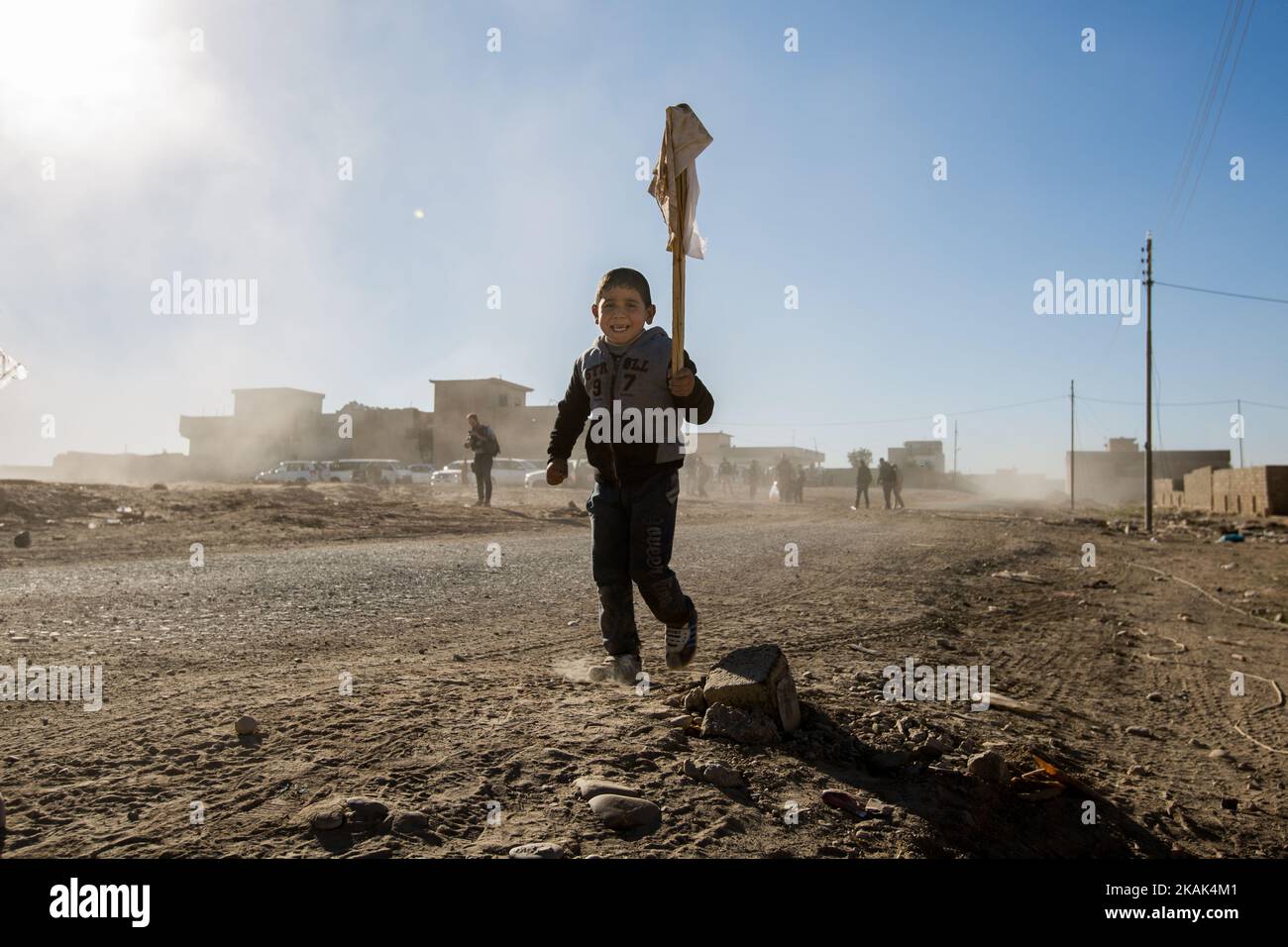 (11/25/2016) Un ragazzo porta una bandiera bianca in alto nell'aria dopo che lui e la sua famiglia fuggirono dall'Isis a Mosul, in Iraq, e raggiunsero il territorio liberato nel distretto orientale di Hay Samah. (Foto di Sebastian Backhaus/NurPhoto) *** Please use Credit from Credit Field *** Foto Stock