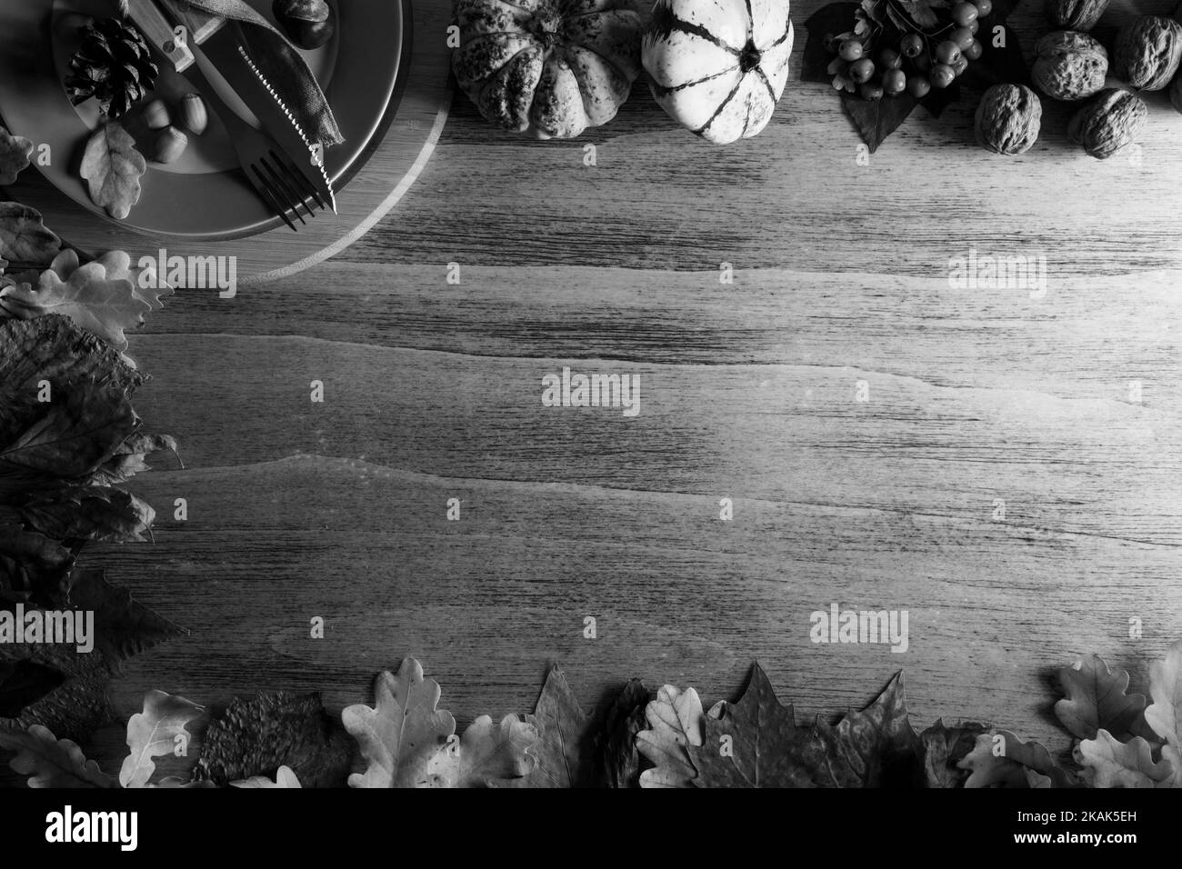Zucche di ringraziamento con frutta e foglie cadute su un tavolo rustico di legno Foto Stock