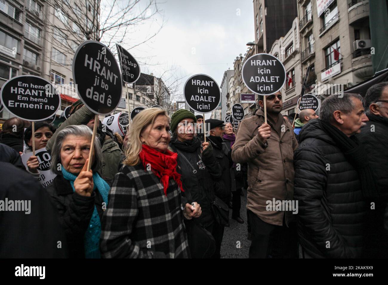 La gente grida slogan mentre tiene cartelli con la scritta "Siamo tutti Hrant, siamo tutti armeni” davanti agli uffici del settimanale armeno Agos durante un raduno commemorativo del decimo anniversario dell'assassinio del giornalista turco-armeno Hrant Dink, a Istanbul, il 19 gennaio 2017. Dieci anni dopo che il giornalista turco-armeno Hrant Dink è stato ucciso a colpi di arma da fuoco a Istanbul, armeni e turchi non hanno ancora raggiunto la riconciliazione di cui sognava. L'assassinio di Dink da parte di un giovane cannoniere il 19 gennaio 2007, vicino agli uffici del giornale Agos che ha fondato, se Foto Stock