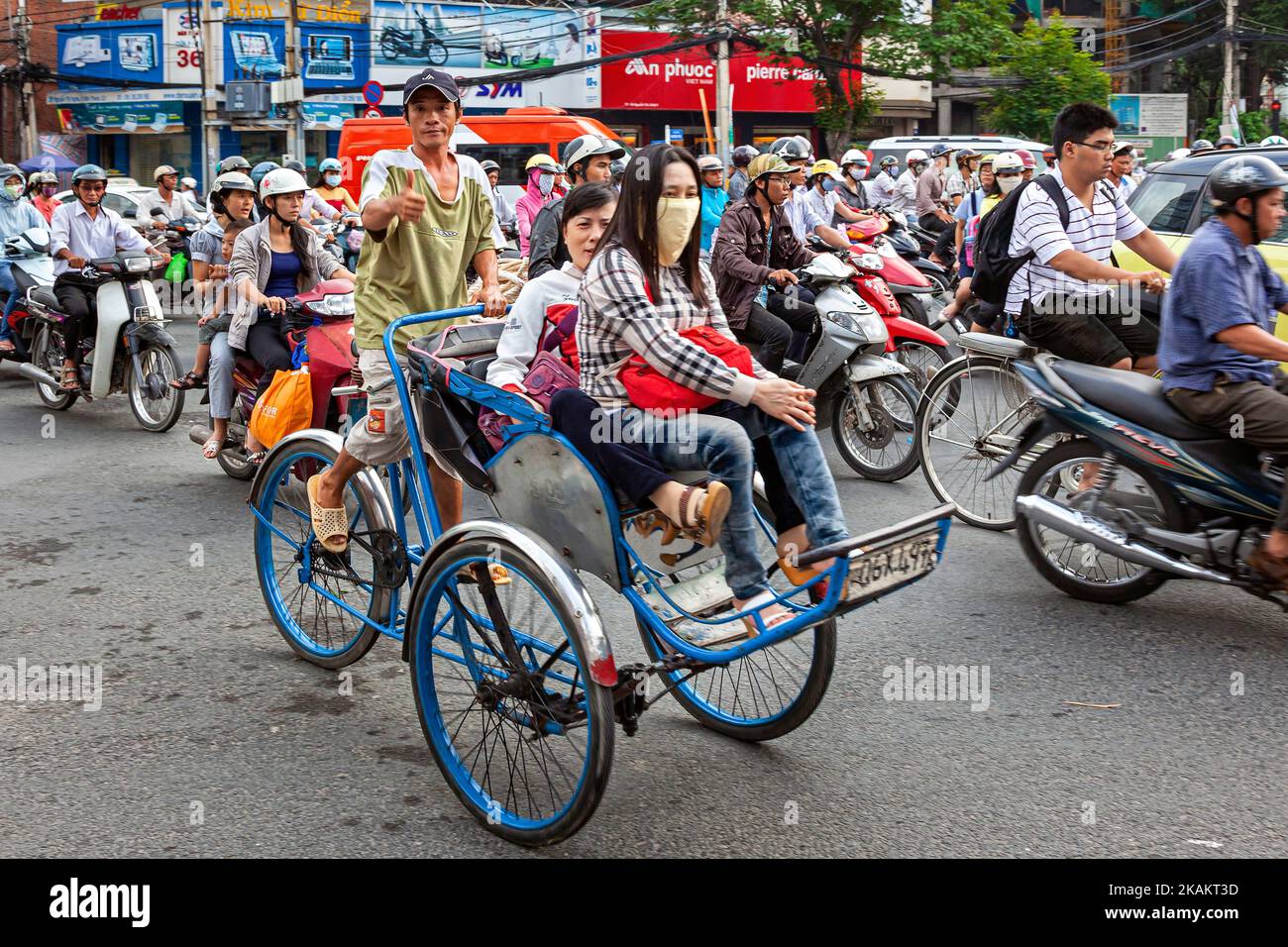 Risciò in bicicletta e passeggeri nel traffico Jam, centro di ho Chi Minh City, Vietnam Foto Stock