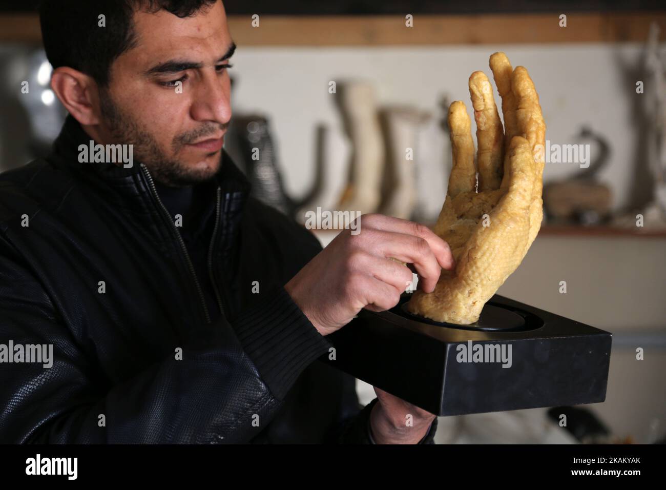 L'artista palestinese Mohammed Abu Hashish, 29 anni, utilizza la cera d'api per produrre modelli di arto umano, nel suo laboratorio, nel campo profughi di al-Magasi, nel centro della striscia di Gaza, il 28 febbraio 2017. (Foto di Majdi Fathi/NurPhoto) *** Please use Credit from Credit Field *** Foto Stock
