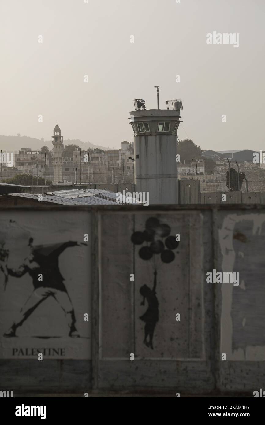 Le opere d'arte di Banksy sono visibili su un muro di fronte a una torre di guardia, vicino al 'Walled Off Hotel' dell'artista di strada britannico Banksy, che si trova proprio di fronte al muro di separazione di Israele, il 11 marzo 2017, a Betlemme, in Cisgiordania. (Foto di Corinna Kern/NurPhoto) *** Please use Credit from Credit Field *** Foto Stock