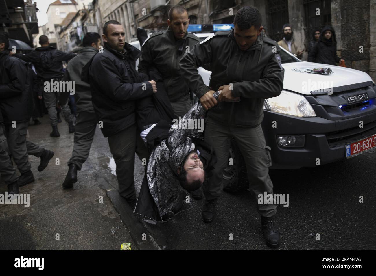 I poliziotti arrestano un uomo ultra-ortodosso durante gli scontri dopo che una bambola di soldato è stata appesa ad un edificio come parte della protesta ebrea ultra-ortodossa contro la coscrizione nel quartiere Mea Shearim di Gerusalemme, Israele, 13 marzo 2017, durante le celebrazioni della festa ebraica di Purim. Purim è una celebrazione della salvezza degli ebrei dal genocidio nell'antica Persia, come raccontato nel Libro di Ester. (Foto di Corinna Kern/NurPhoto) *** Please use Credit from Credit Field *** Foto Stock