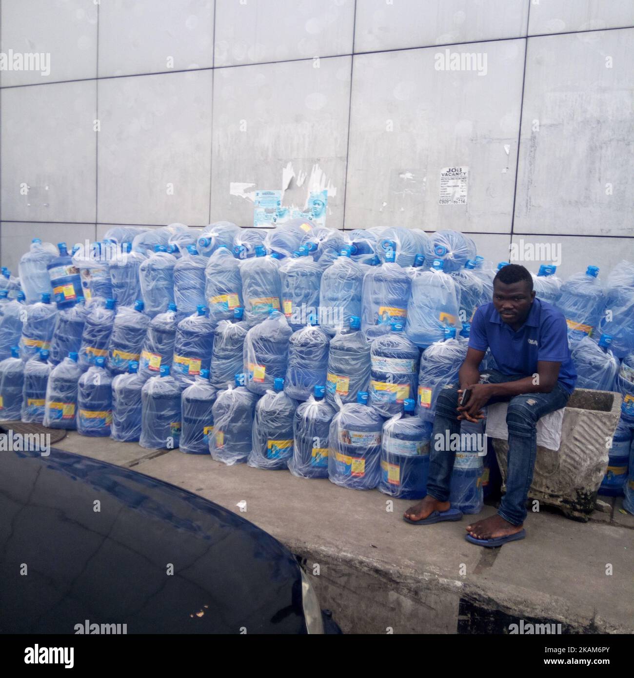 Vendor siede vicino a barili d'acqua ad Apagbon a Lagos, Nigeria, mercoledì 22 2017 marzo. Il costo di ottenere acqua di qualità a Lagos è in aumento ogni giorno. I residenti stanno chiedendo al governo di fornire acqua portatile e accessibile come il mondo segna la Giornata Mondiale dell'acqua. (Foto di Adekunle Ajayi/NurPhoto) *** Please use Credit from Credit Field *** Foto Stock