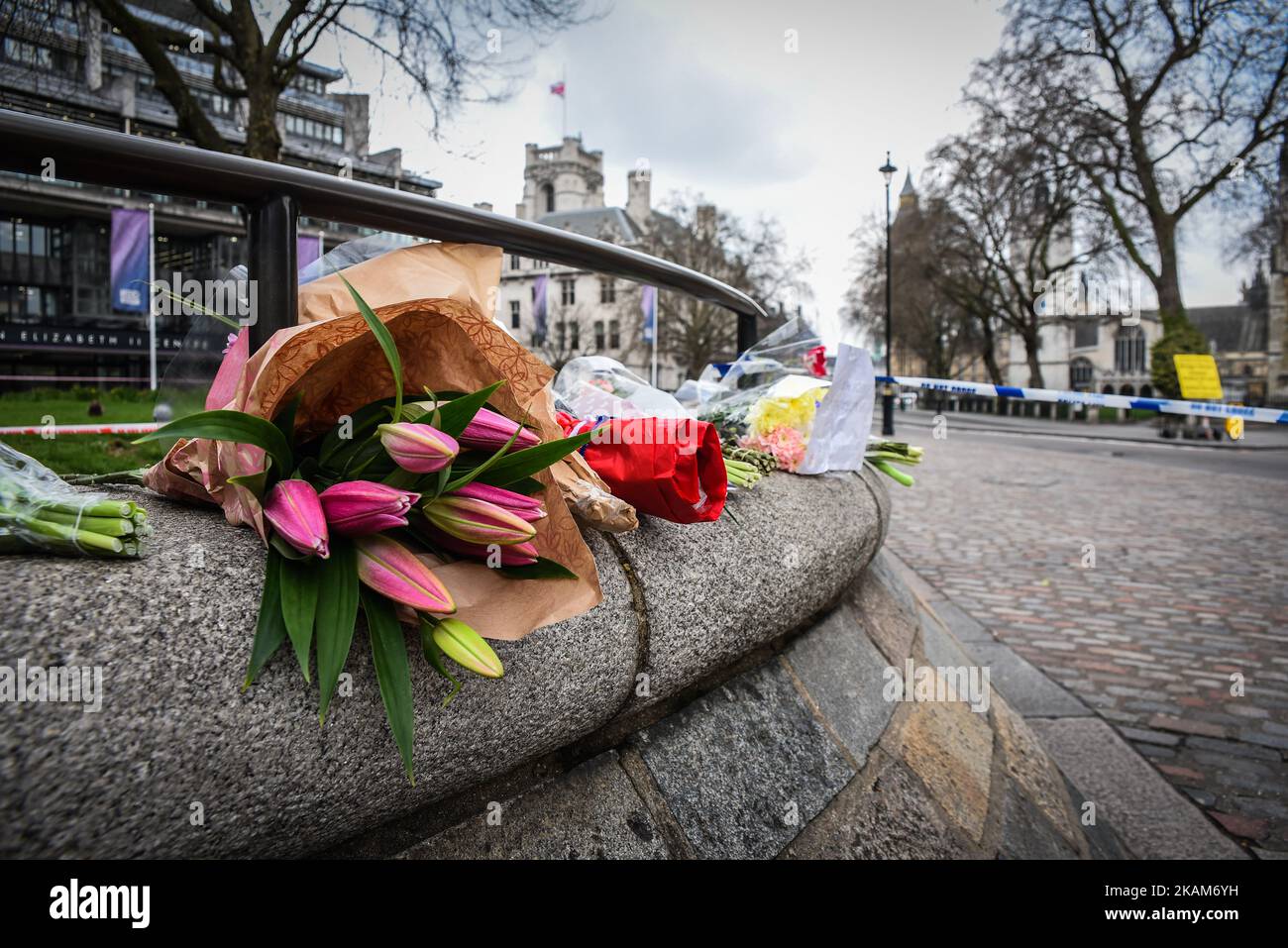 Tributi floreali sono visti vicino ad un cordone di polizia a Westminster a Londra, il 23 marzo 2017. La polizia continua le indagini dopo l'attentato terroristico di ieri a Londra, in cui un'auto è stata guidata nei pedoni sul ponte di Westminster e poi nelle ringhiere al di fuori delle Camere del Parlamento, dove un abile ha pugnalato un ufficiale di polizia chiamato PC Keith Palmer, che è poi morto per le sue ferite. L'attaccante è morto anche dopo che le forze di sicurezza lo hanno sparato. Altre due persone sono morte nell'incidente e circa 40 sono rimaste ferite, alcune 'catastroficamente?. Una donna è stata tirata in vita dal Tamigi dopo riferito Foto Stock