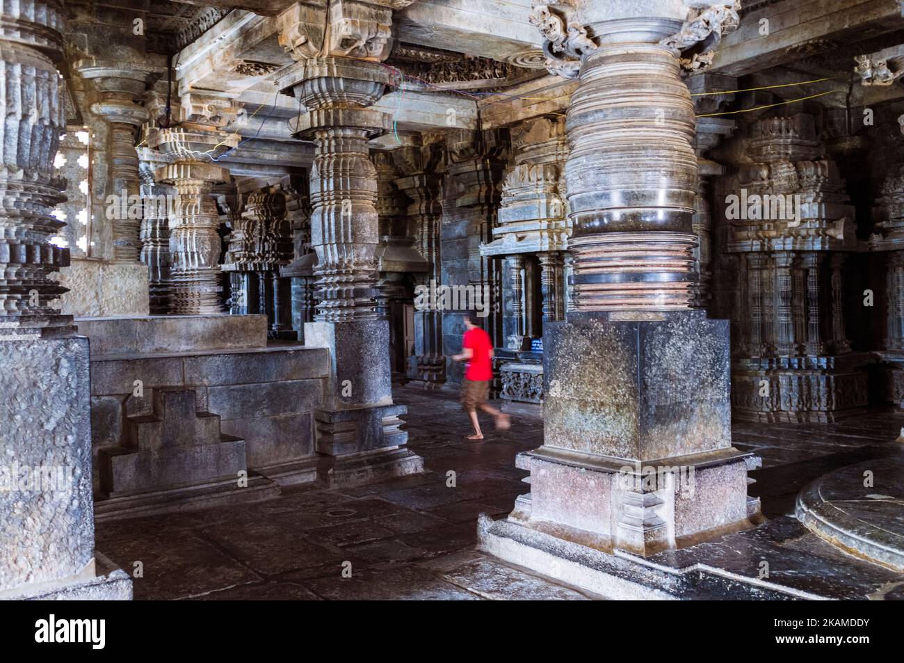 Halebid, Karnataka, India : Un bambino corre tra le colonne all'interno del Tempio Hoysaleswara del 12th ° secolo. Foto Stock