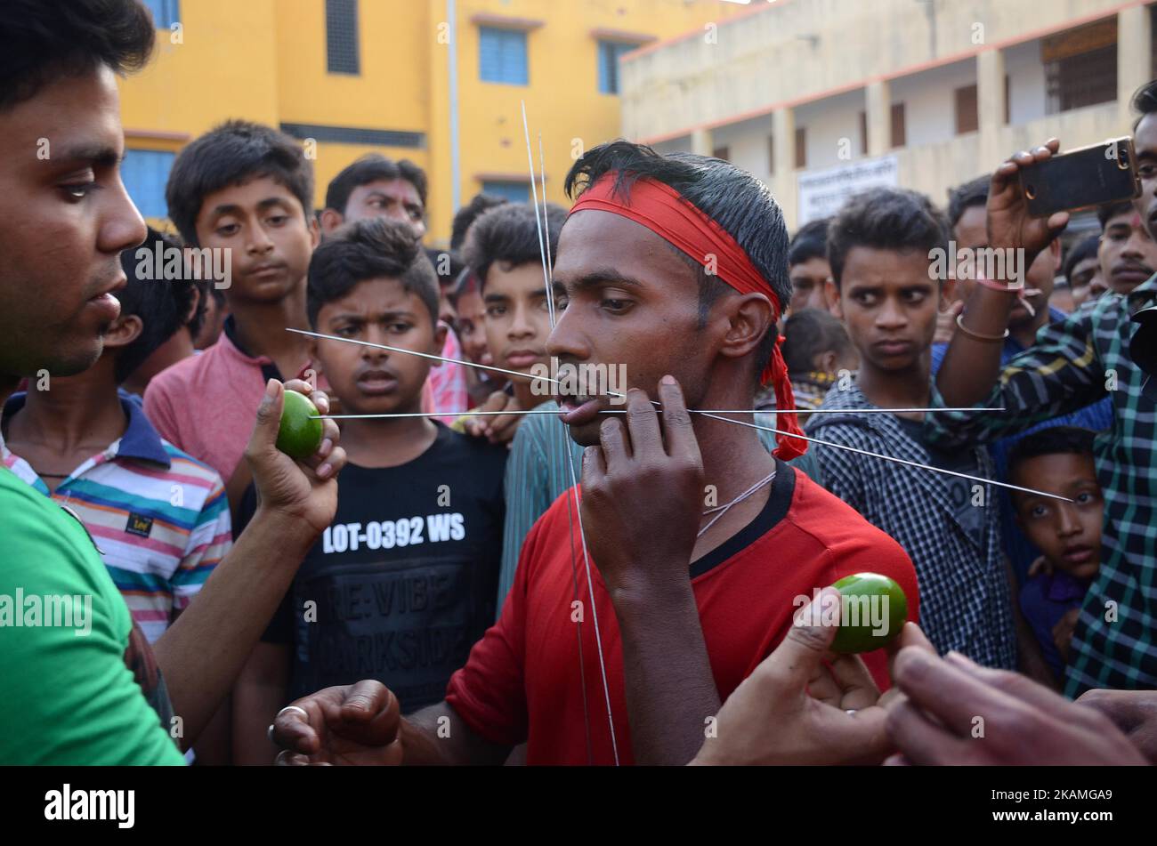 Il devoto indù indiano trafitto con la canna di ferro durante il festival di Gajan nel distretto di Burdwan del Bengala occidentale, India il venerdì, 14th aprile 2017.Gajan è un festival indù celebrato principalmente nello stato indiano del Bengala occidentale. È associata a divinità come Shiva, Neel e Dharmathakur. Gajan si estende per circa una settimana, a partire dall'ultima settimana di Chaitro continuando fino alla fine dell'anno Bengalese. Si conclude con Charak Puja. I partecipanti a questo festival sono noti come Sannyasi o Bhokta. Il tema centrale di questo festival è la soddisfazione che deriva dalla devozione e dal sacrificio. (Foto di Sonali Pal Cha Foto Stock