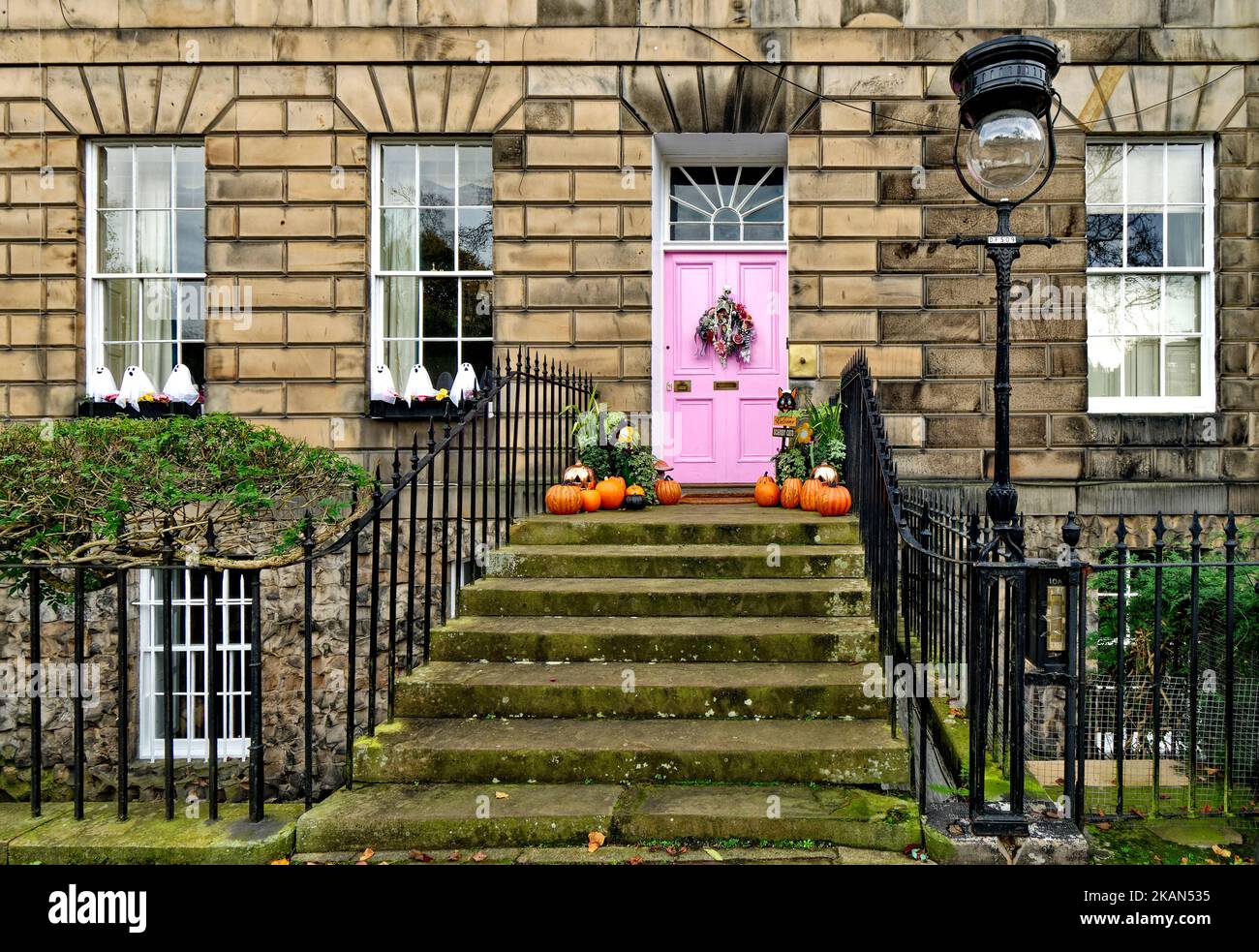Edinburgh New Town Scotland una porta rosa su una casa Drummond Place con una corona e zucche di Halloween arancione sulla scalinata Foto Stock