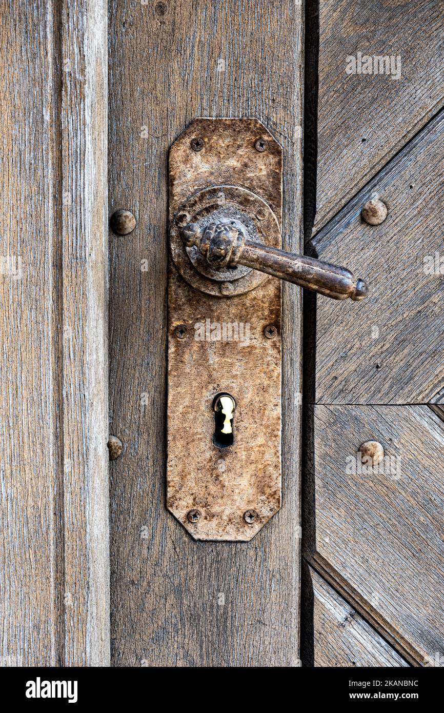 Vecchia porta in legno con maniglia arrugginita Foto Stock