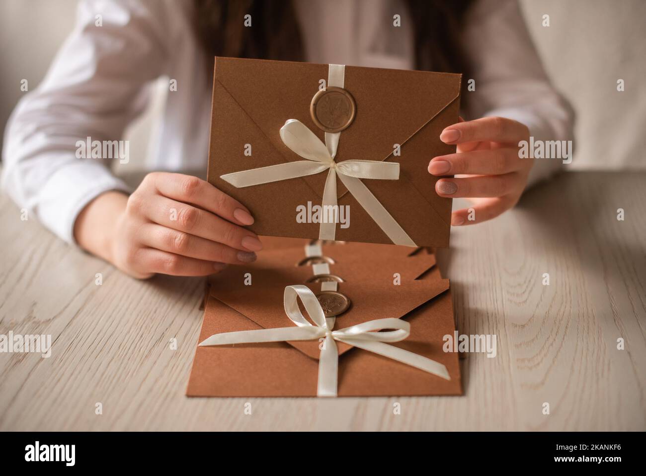 Le buste di carta di bronzo fatte a mano conservano le schede della data nelle mani della donna Foto Stock