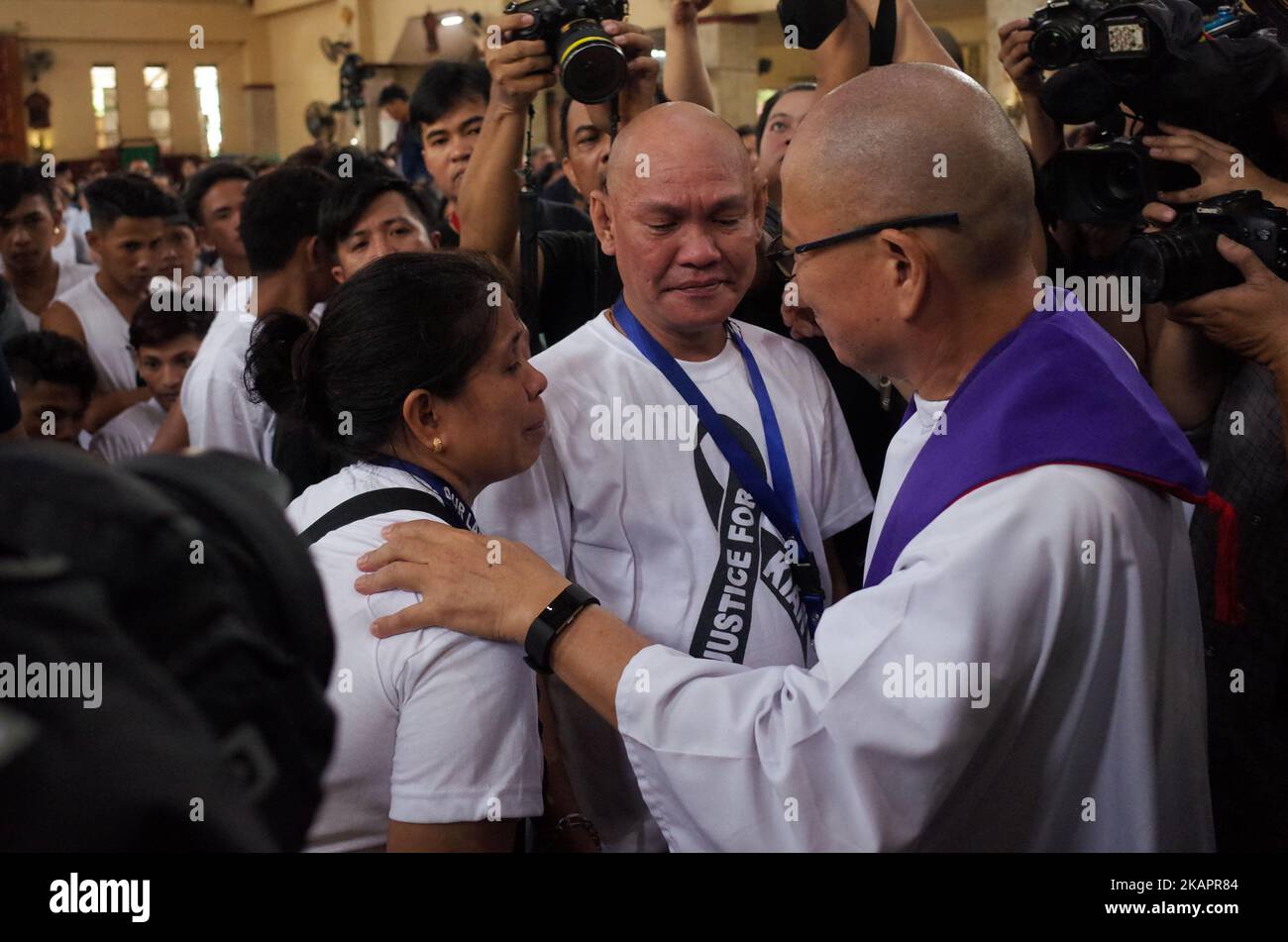 Un sacerdote conforta Lorenza Delos Santos e Saldy Delos Santos, durante i funerali del figlio Kian Loyd Delos Santos a Manila, Filippine, sabato 26 agosto 2017. Kian Loyd Delos Santos, uno studente di 17 anni che è stato ucciso dai poliziotti in un presunto sparo, è diventato un punto di incontro per gli attivisti e gli oppositori del presidente Rodrigo Duterte per criticare la sanguinosa guerra alla droga nelle Filippine, che, secondo i dati ufficiali, ha causato almeno 7.000 morti e 90.000 arresti. (Foto di Richard James Mendoza/NurPhoto) Foto Stock