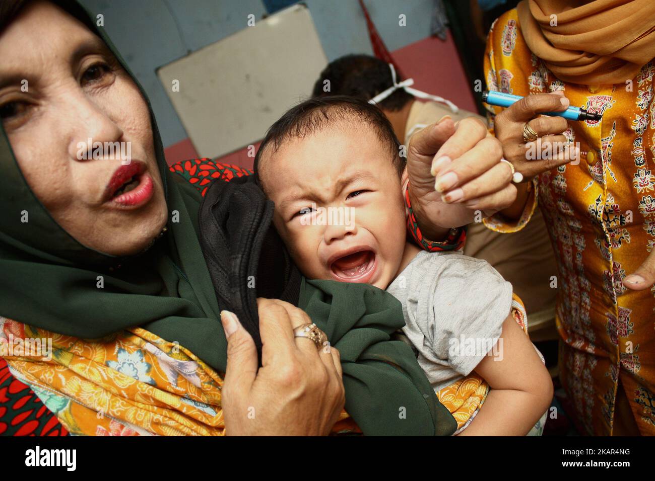 Gli agenti sanitari hanno iniettato il vaccino contro il morbillo Rubella ai bambini in un posto di servizio sanitario integrato a Wanasari Village, West Java, il 8 settembre 2017. Il governo indonesiano si rivolge a un minimo del 95% o a 34.964.384 bambini in tutta l'Indonesia di età compresa tra 9 mesi e 15 anni, ottenendo il vaccino contro la RM, attraverso il programma della campagna di immunizzazione, che inizia da agosto a settembre 2017 e agosto-settembre 2018. La campagna di immunizzazione contro la RM è la realizzazione di un programma governativo per eliminare il morbillo e la rosolia in Indonesia entro il 2020. (Foto di Aditya Irawan/NurPhoto) Foto Stock