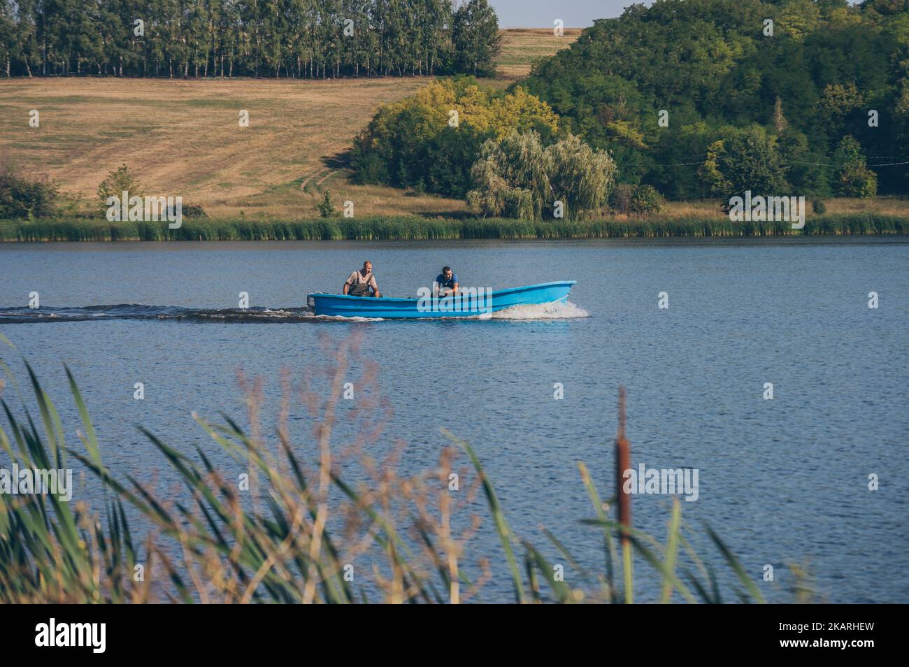 Due fyshemen in motoscafo navigano ssecando le onde sull'acqua del fiume Foto Stock