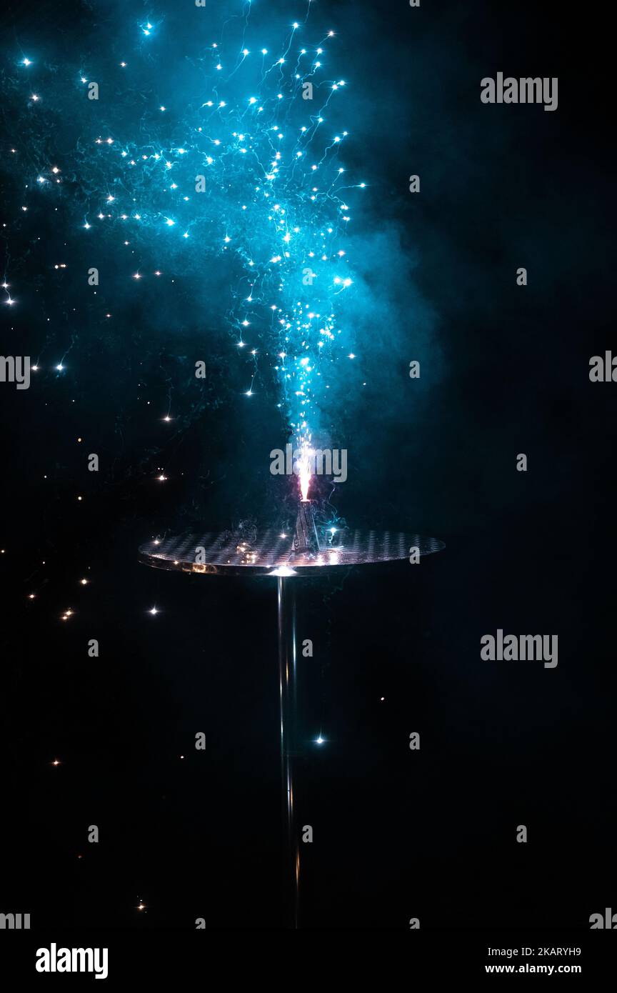 Un fuoco d'artificio blu rilasciato da un palcoscenico di metallo al buio per il nuovo anno Foto Stock Un fuoco d'artificio blu rilasciato da un palcoscenico di metallo al buio per il nuovo anno Foto Stock