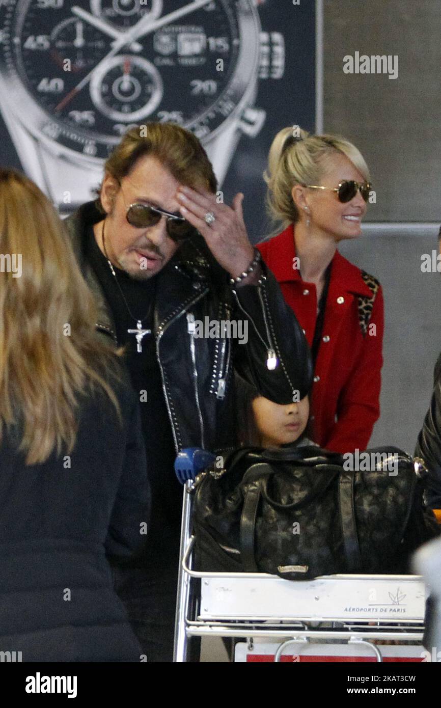Rock Star Johnny Hallyday con la moglie Laeticia Hallyday e i bambini visti arrivare all'aeroporto Charles de Gaulles a Parigi, in Francia, il 15 ottobre 2014. (Foto di Mehdi Taamallah / NurPhoto) Foto Stock