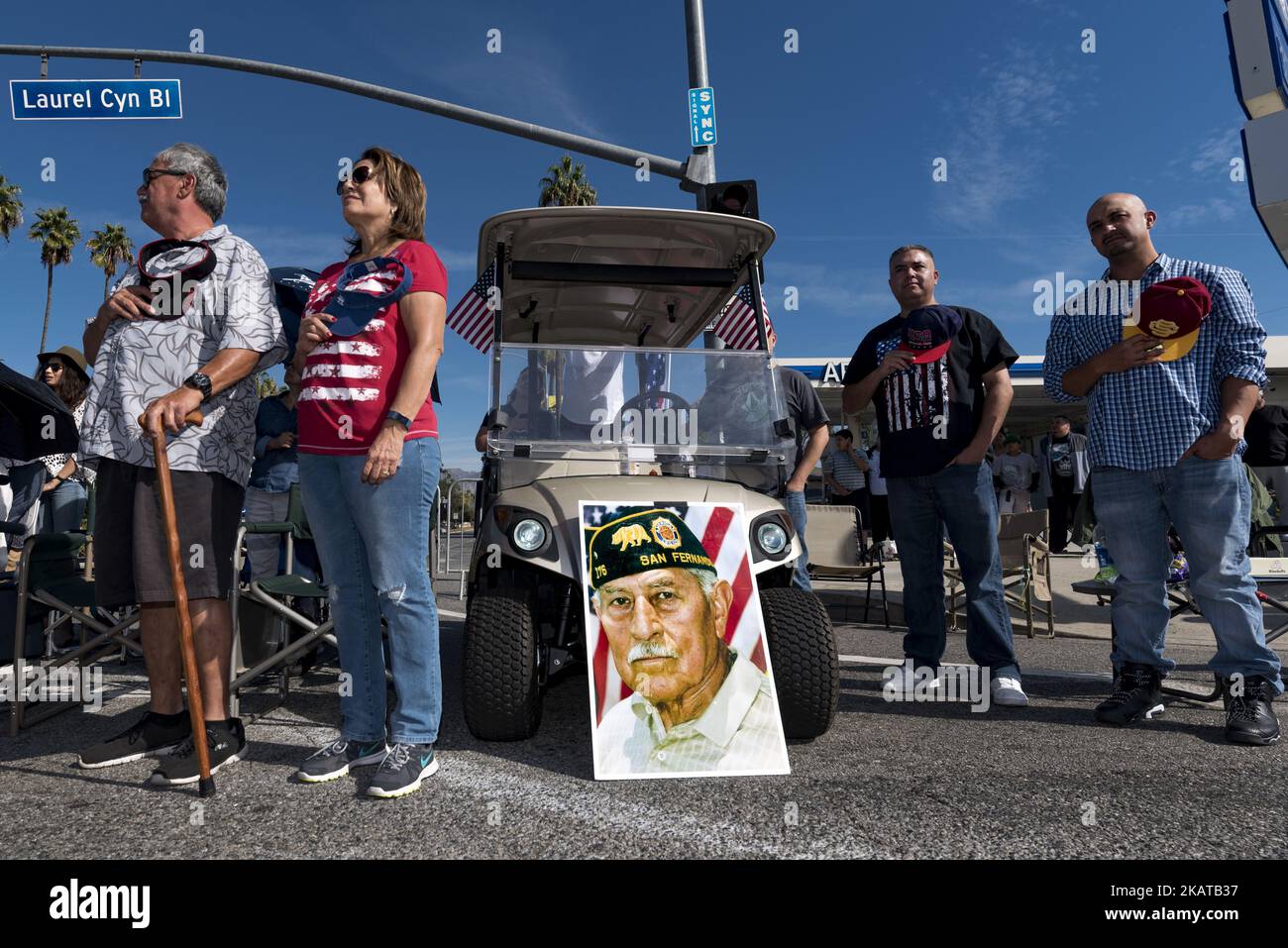 Persone in piedi per il National Anthem accanto a un ritratto del veterano della seconda guerra mondiale, Estevan M. Guerrero durante la San Fernando Valley Veterans' Day Parade a Los Angeles, California, il 11 novembre 2017. Veterans Day è una festa federale negli Stati Uniti in onore dei veterani militari americani. Celebrato annualmente il 11 novembre per segnare la firma dell'armistizio del 1918 che concluse la prima guerra mondiale (Foto di Ronen Tivony/NurPhoto) Foto Stock