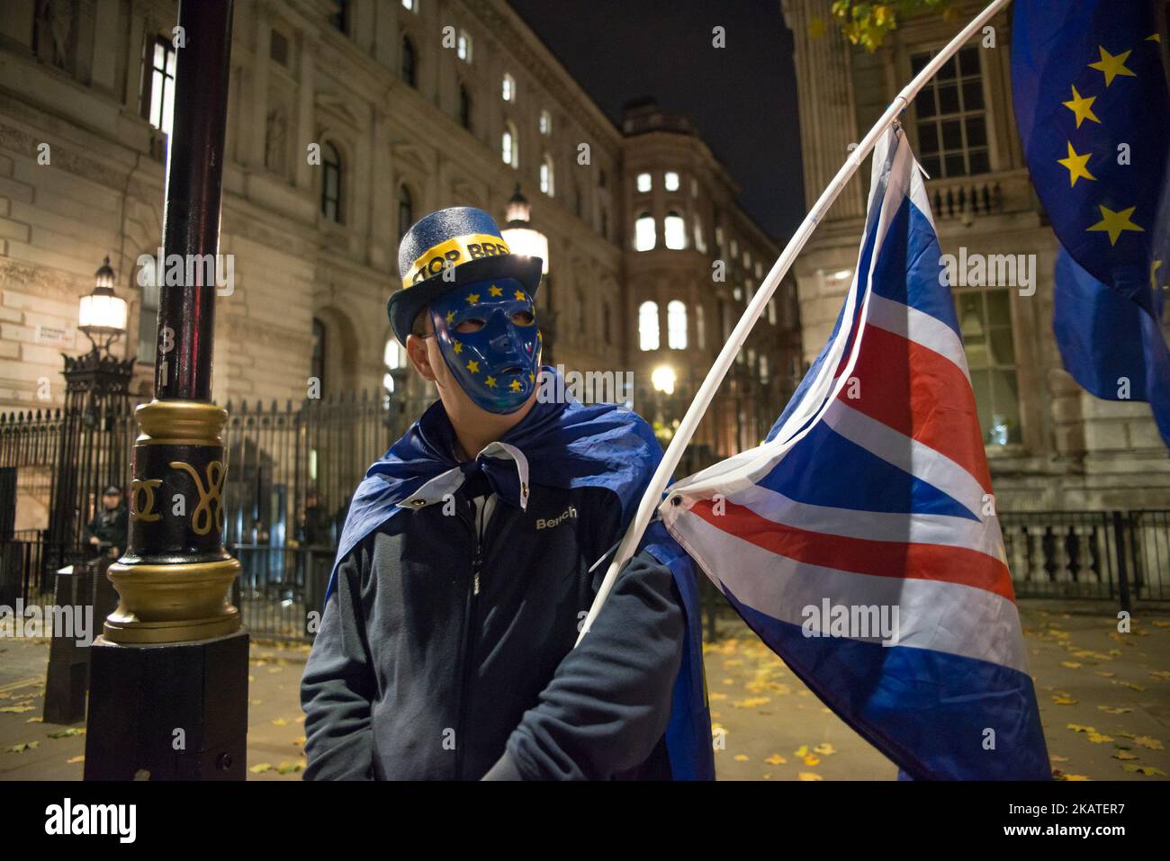 Un dimostratore anti-Brexit sventola la bandiera dell’UE e quella dell’Unione, al di fuori di Downing Street, Londra, il 21 novembre 2017. La protesta si è svolta la sera prima del giorno del bilancio. Nel Regno Unito, la giornata del bilancio è il giorno in cui il Cancelliere dello scacchiere consegna il bilancio al Gabinetto e poi alla Camera dei Comuni. (Foto di Alberto Pezzali/NurPhoto) Foto Stock