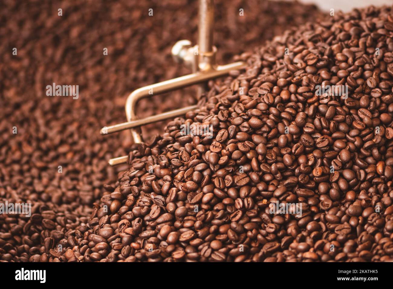 Tostatura dei chicchi di caffè in una vecchia macchina professionale per la tostatura del caffè o in primo piano Foto Stock