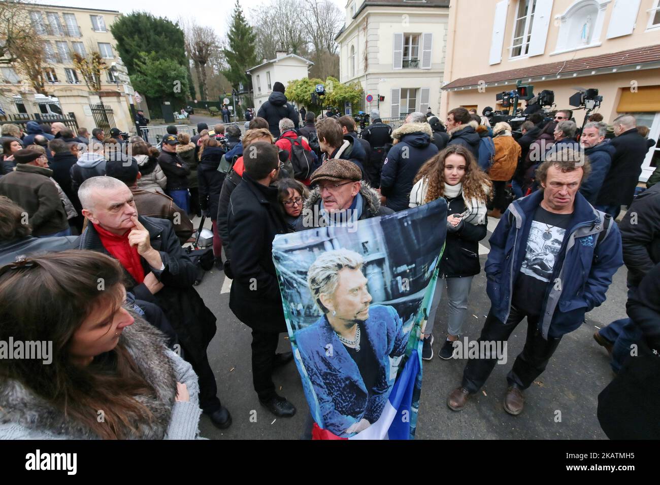 Un fan del cantante e attore francese Johnny Hallyday tiene un ritratto di lui vicino alla sua casa a Marnes-la-Coquette il 6 dicembre 2017. Johnny Hallyday, la rock star più conosciuta della Francia, è morta a 74 anni dopo una battaglia contro il cancro ai polmoni. (Foto di Michel Stoupak/NurPhoto) Foto Stock