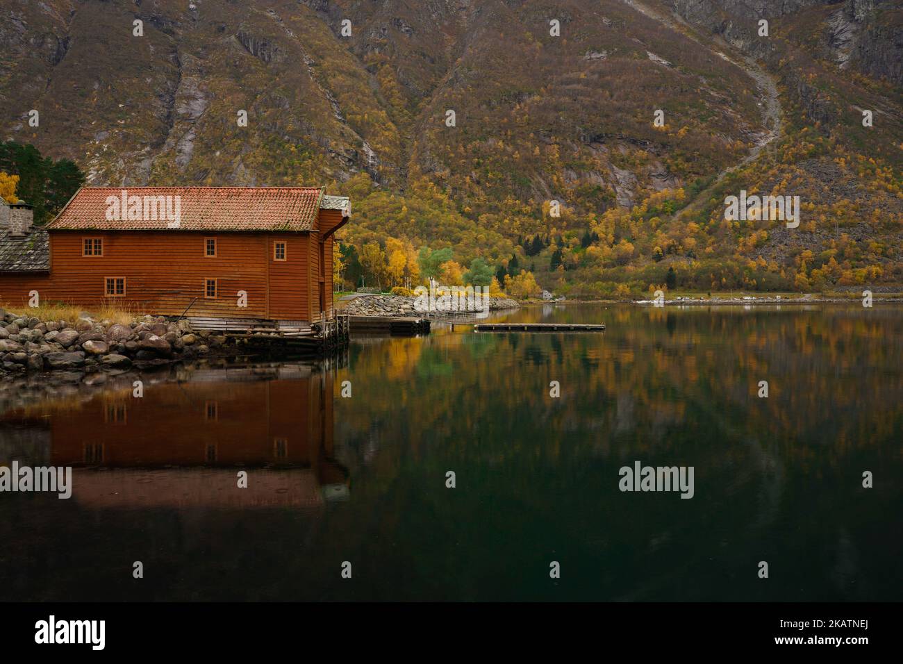 Autunno / Autunno Paesaggio fiordo acqua con barca arancione casa 'Sjøbua', edificio protetto in Norvegia Hardangerfjord Eidfjord Foto Stock