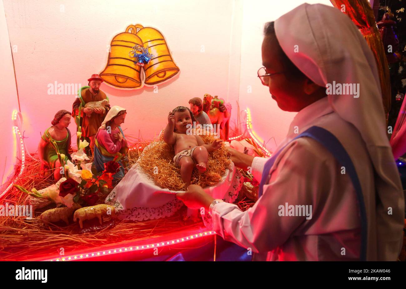 Una suora tiene il piccolo Gesù Cristo in una mangiatoia nella Cattedrale di Santa Maria a Kakrail a Dhaka, la vigilia di Natale di domenica 24 dicembre 2017. La comunità cristiana celebra domani la Giornata di Natale in Bangladesh con la festa che commemora il compleanno di Gesù Cristo come in altre parti del mondo.i cristiani di diversi gruppi celebreranno la festa con il fervore religioso e la festa, offrendo preghiere speciali, illuminando chiese, Installazione di alberi di Natale di fortuna a case e luoghi di culto e missioni. (Foto di Sony Ramany/NurPhoto) Foto Stock