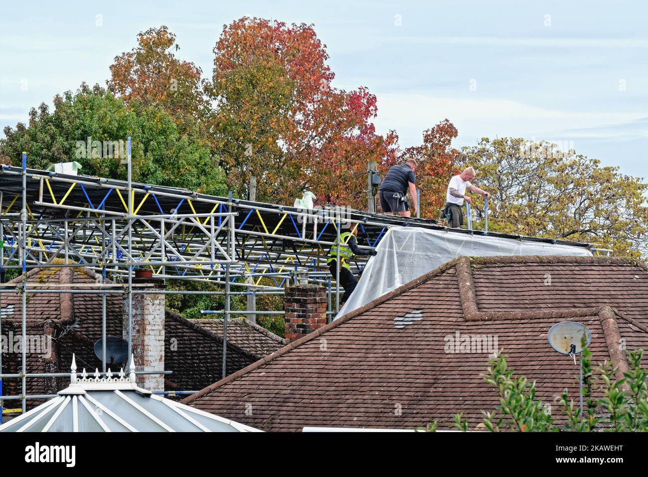 Ponteggi erigendo impalcatura su un bungalow suburbano prima di lavori di costruzione da eseguire sul tetto, Shepperton Inghilterra UK Foto Stock