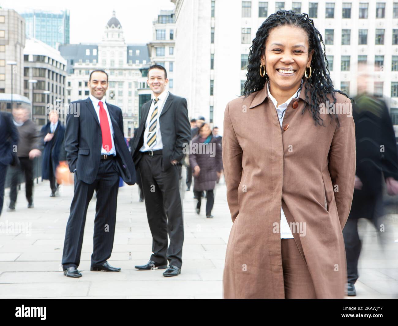 Professionisti di Londra, Business Woman. Una donna d'affari nera matura che guida la sua squadra variegata sulle strade della città. Da una serie di immagini correlate. Foto Stock