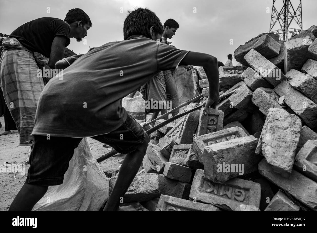 Un ragazzo di rifugiati Rohingya e altri raccolgono mattoni nel campo profughi di Kutupalong, vicino al Bazar di Cox, Bangladesh, 24 novembre 2017. (Foto di Szymon Barylski/NurPhoto) Foto Stock