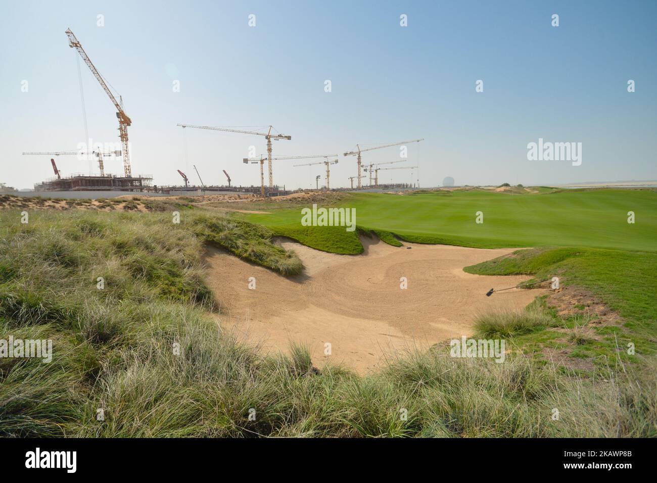 Una vista di Yas collega il campo da golf con un nuovo cantiere sullo sfondo. Il sentimento nel settore edile degli Emirati Arabi Uniti è ottimista al momento mentre la regione si prepara per il prossimo Expo 2020. L’evento potrebbe essere un catalizzatore per l’industria edile degli Emirati Arabi Uniti. L’aumento dei prezzi del petrolio potrebbe essere vantaggioso anche per i contraenti, dal momento che i governi regionali stanno iniziando a riavviare vecchi progetti o a investire nello sviluppo di nuove infrastrutture. Le uniche preoccupazioni rimangono circa il volume delle opere dopo il 2020. Martedì 20 febbraio 2018 ad Abu Dhabi, Emirati Arabi Uniti. (Foto di Artur Widak/NurPho Foto Stock