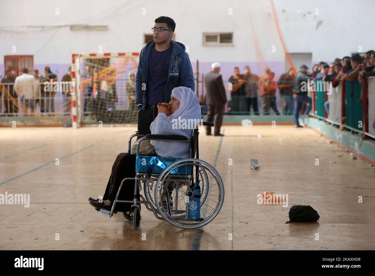 Decine di palestinesi aspettano nella Abu Yousef al-Najjar Hall, nella città di Khan Yunis, nella striscia di Gaza meridionale, il 13 aprile 2018, per recarsi in Egitto attraverso il valico di frontiera di Rafah, temporaneamente aperto. Le autorità egiziane hanno aperto la traversata di Rafah in entrambe le direzioni giovedì per tre giorni, consentendo il passaggio di studenti che studiano all'estero, persone che lavorano all'estero e persone che necessitano di cure mediche al di fuori di Gaza. Tuttavia, il periodo di apertura è breve considerando che decine di migliaia di gazan, tra cui studenti, uomini d'affari e malati, sono in lista d'attesa per lasciare Gaza thro Foto Stock