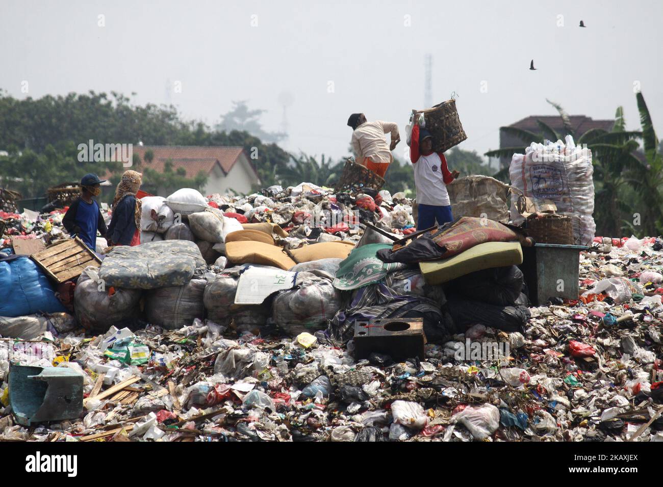 I sequestratori risolvono i rifiuti di plastica riciclabili a discariche illegali sulle rive del fiume CBL, distretto di Bekasi, Bekasi, Giava Occidentale sabato 14 aprile 2018. Con una popolazione di 2,4 milioni di persone, Bekasi come città satellite per Giacarta, si trova ad affrontare gravi problemi legati al trattamento dei rifiuti, che ha raggiunto le 1.700 tonnellate al giorno. In base ai dati dell'Agenzia per l'ambiente di Kota Bekasi, solo 600 tonnellate di rifiuti possono essere trasportate in discarica, mentre le restanti 1.100 tonnellate vengono smaltite in discariche illegali, come nei pressi di insediamenti o lungo il fiume. (Foto di Aditya Irawan/NurPhoto) Foto Stock