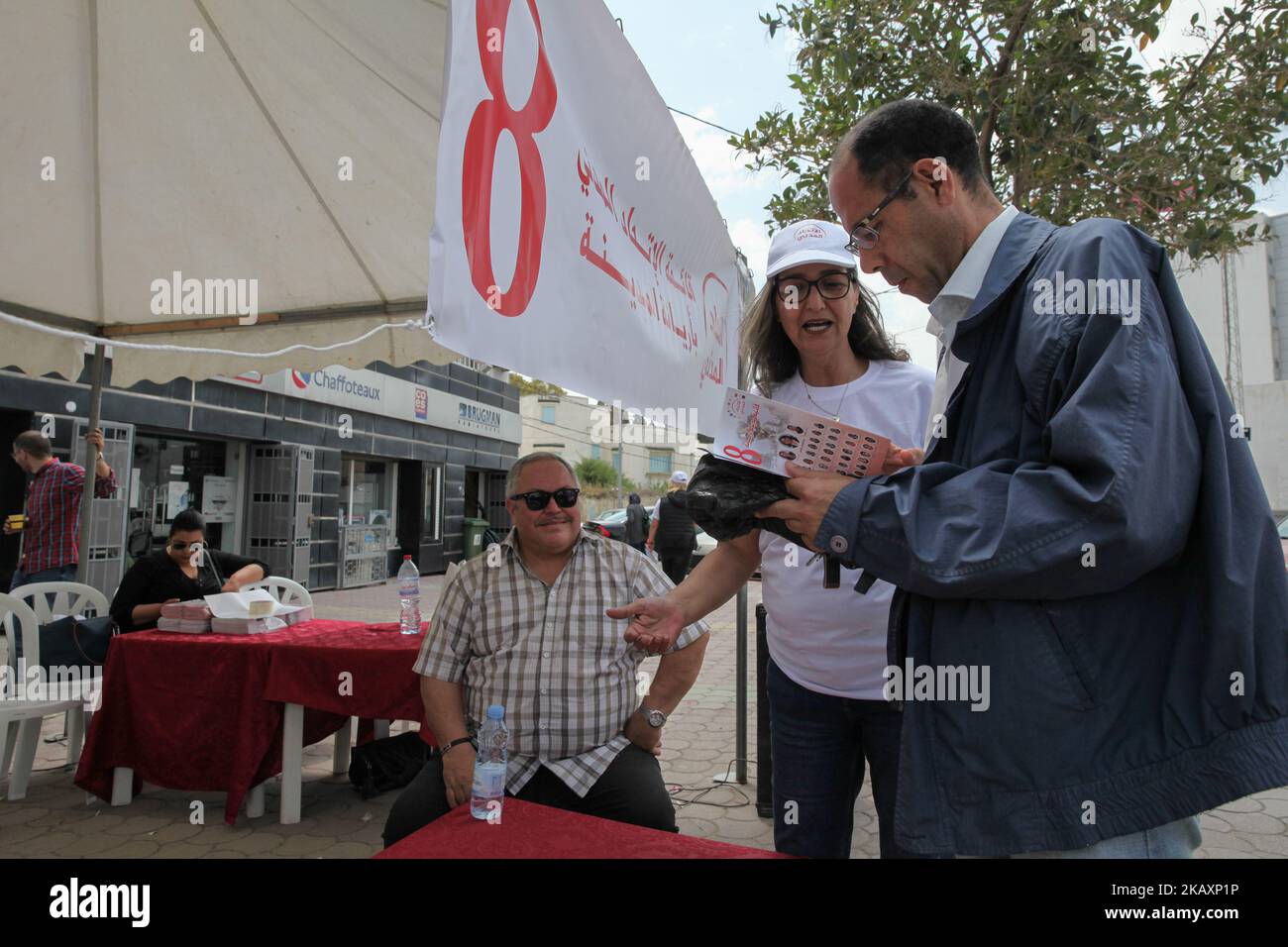Una donna sostenitrice dell'Unione civile, una coalizione politica di 11 partiti, presenta il programma elettorale ad un tunisino all'interno di una tenda promozionale installata in strada nel Governatorato di Ariana, nel nord-est della Tunisia, il 28 aprile 2018, come campagna di sostenitori per le elezioni comunali. I tunisini si dirigeranno ai sondaggi il 6 maggio per votare alle prime elezioni comunali libere del paese dopo la rimozione del presidente Zine El Abidine ben Ali e del suo governo nel 2011. (Foto di Chardy ben Ibrahim/NurPhoto) Foto Stock