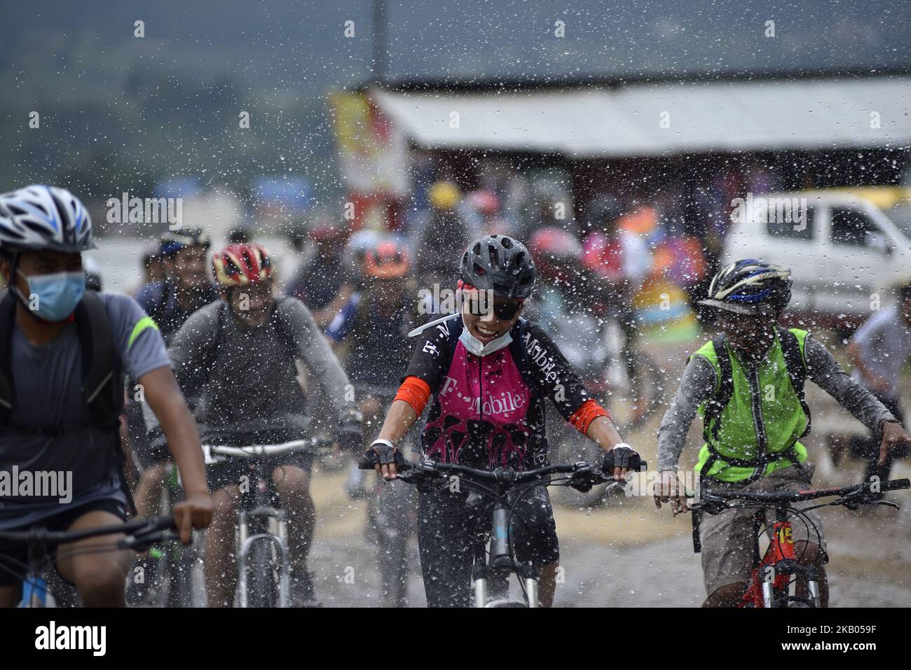 I ciclisti godono come gocce d'acqua spruzza dalla gente durante Kathmandu Kora Cycling 2018 CORSA per una causa a Chobhar, Kathmandu, Nepal il sabato 21 luglio 2018. Piloti provenienti dal Nepal e da diversi paesi hanno partecipato a una sfida di 50 km, 75 km e 100 km intorno Kathmandu Valley sulla sua ottava edizione di KATHMANDU KORA. (Foto di Narayan Maharjan/NurPhoto) Foto Stock