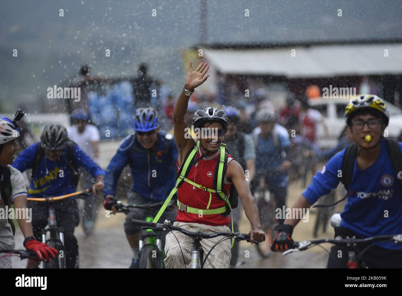 I ciclisti godono come gocce d'acqua spruzza dalla gente durante Kathmandu Kora Cycling 2018 CORSA per una causa a Chobhar, Kathmandu, Nepal il sabato 21 luglio 2018. Piloti provenienti dal Nepal e da diversi paesi hanno partecipato a una sfida di 50 km, 75 km e 100 km intorno Kathmandu Valley sulla sua ottava edizione di KATHMANDU KORA. (Foto di Narayan Maharjan/NurPhoto) Foto Stock