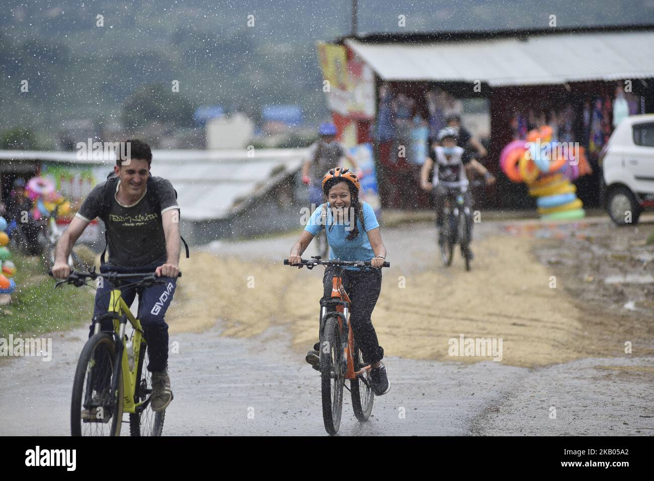 I ciclisti godono come gocce d'acqua spruzza dalla gente durante Kathmandu Kora Cycling 2018 CORSA per una causa a Chobhar, Kathmandu, Nepal il sabato 21 luglio 2018. Piloti provenienti dal Nepal e da diversi paesi hanno partecipato a una sfida di 50 km, 75 km e 100 km intorno Kathmandu Valley sulla sua ottava edizione di KATHMANDU KORA. (Foto di Narayan Maharjan/NurPhoto) Foto Stock