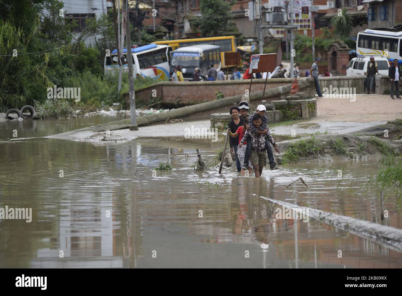 Persone nepalesi che attraversano le acque di alluvione a causa delle incessanti precipitazioni a Bhaktapur, Nepal, lunedì 06 agosto 2018. La vita normale in tutto il paese, compresa la valle di Kathmandu, è stata colpita a causa delle precipitazioni incessanti. (Foto di Narayan Maharjan/NurPhoto) Foto Stock