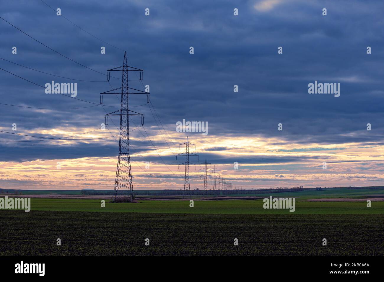 Piloni di potenza e linee elettriche ad alta tensione contro il cielo con nuvole in bassa Austria Foto Stock