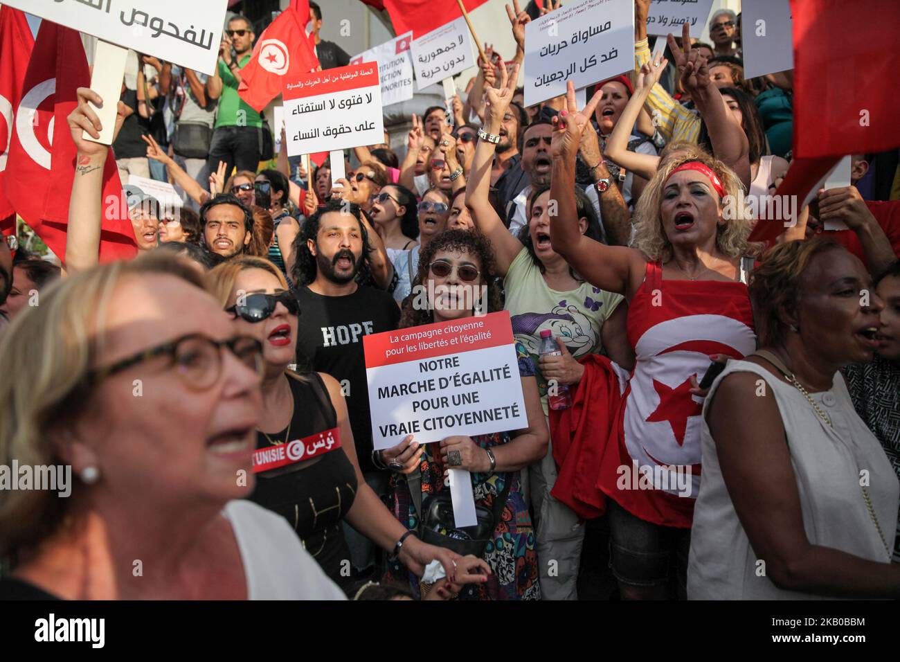 Le donne si alzano cartelli che recitano "la nostra marcia per la parità di cittadinanza reale” durante la celebrazione della Giornata Nazionale della Donna in Avenue Habib Bourguiba a Tunisi, Tunisia, il 13 agosto 2018. I manifestanti hanno chiesto la parità di genere, la parità di successione per le donne, i diritti delle LGBT e i diritti delle donne tunisine. I manifestanti hanno protestato anche contro il partito islamico Ennahda e hanno espresso il loro sostegno al Comitato per le libertà individuali e l'uguaglianza (COLIBE). All'inizio della giornata, il presidente tunisino Beji Coid Essebsi ha annunciato che il disegno di legge sulla parità di successione per le donne sarà presentato alla A. Foto Stock
