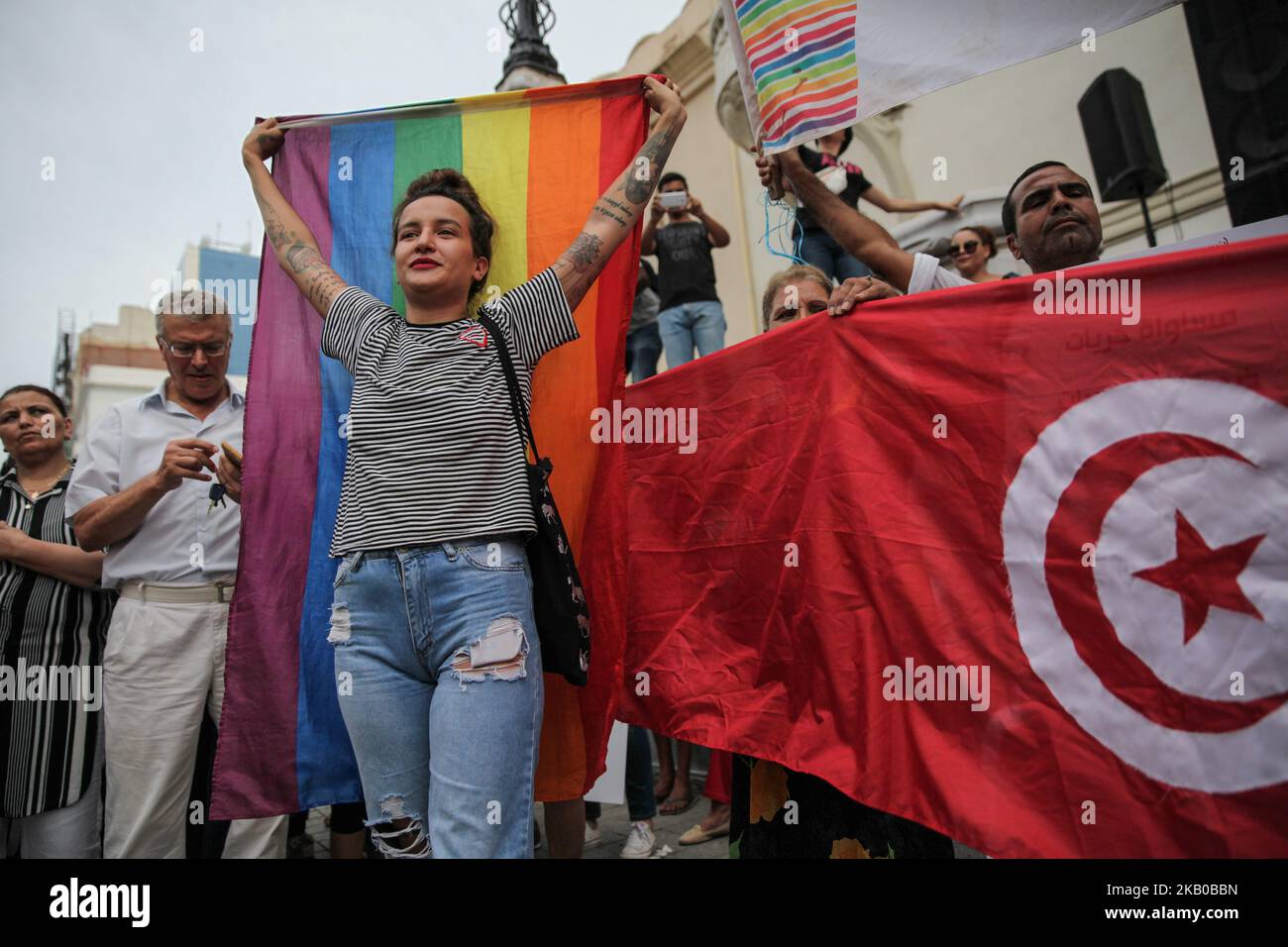 Amina Sboui, ex Femen alza la bandiera arcobaleno mentre partecipa a una manifestazione tenutasi durante la celebrazione della Giornata Nazionale della Donna in avenue Habib Bourguiba a Tunisi, Tunisia, il 13 agosto 2018. I manifestanti hanno chiesto la parità di genere, la parità di successione per le donne, i diritti delle LGBT e i diritti delle donne tunisine. I manifestanti hanno protestato anche contro il partito islamico Ennahda e hanno espresso il loro sostegno al Comitato per le libertà individuali e l'uguaglianza (COLIBE). All'inizio della giornata, il presidente tunisino Beji Coid Essebsi ha annunciato che verrà presentato il disegno di legge sulla parità di successione per le donne Foto Stock