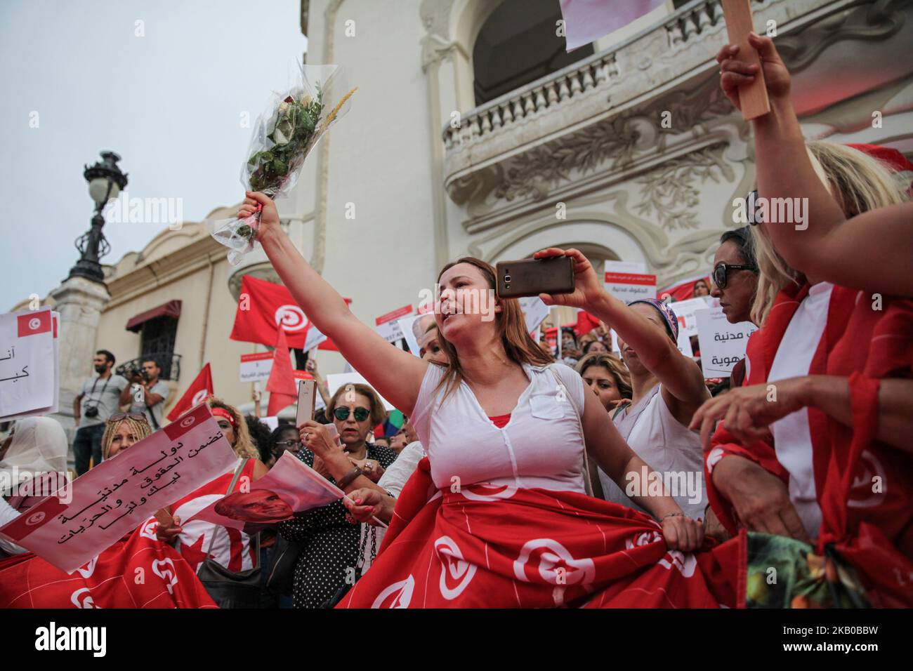 Una donna sorge un mazzo di fiori durante la celebrazione della Giornata Nazionale della Donna in avenue Habib Bourguiba a Tunisi, Tunisia, il 13 agosto 2018. I manifestanti hanno chiesto la parità di genere, la parità di successione per le donne, i diritti delle LGBT e i diritti delle donne tunisine. I manifestanti hanno protestato anche contro il partito islamico Ennahda e hanno espresso il loro sostegno al Comitato per le libertà individuali e l'uguaglianza (COLIBE). All'inizio della giornata, il presidente tunisino Beji Coid Essebsi ha annunciato che il disegno di legge sulla parità di successione per le donne sarà presentato all'Assemblea dei rappresentanti della Peopl Foto Stock