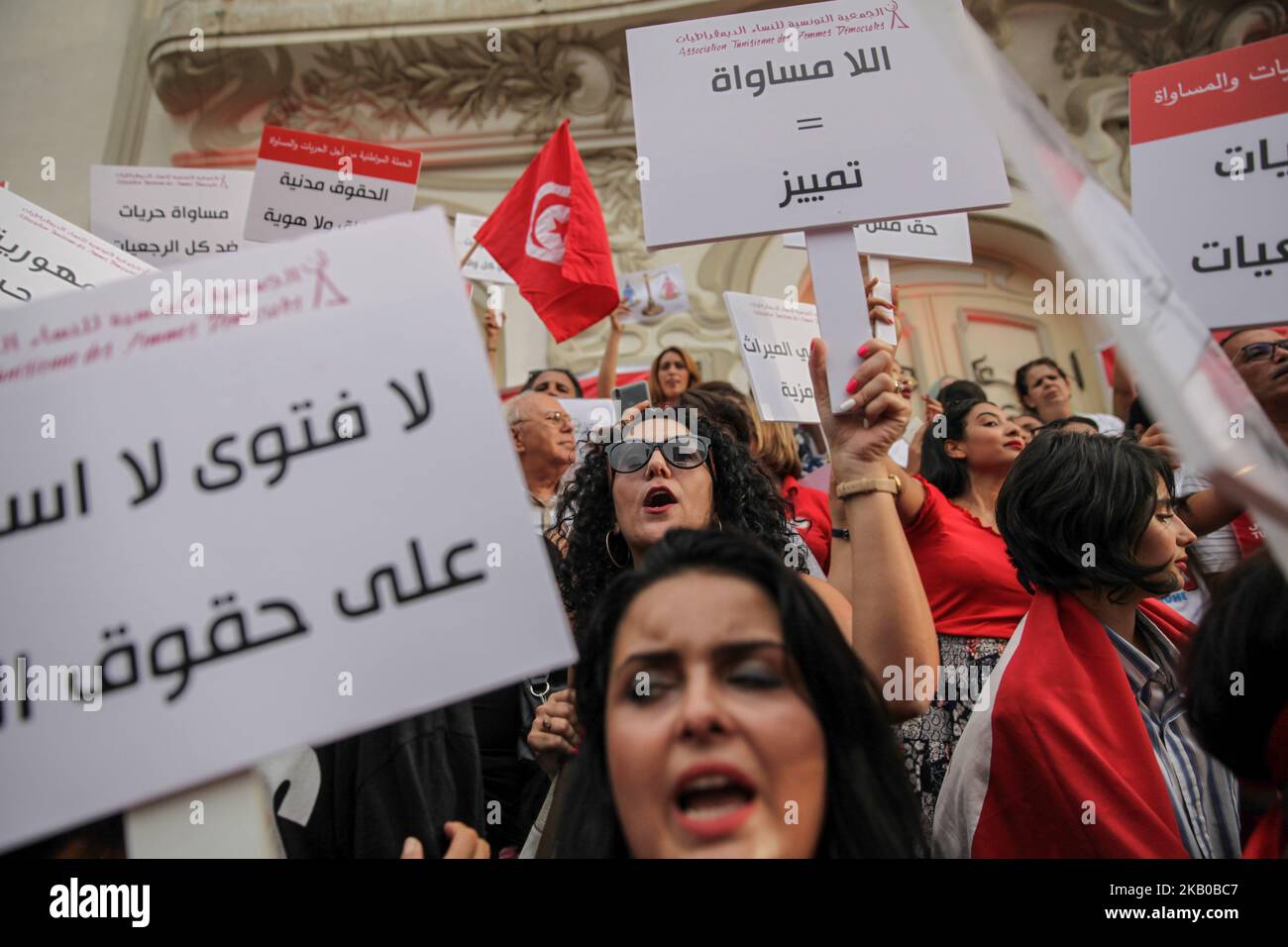 Una donna si alza su un cartello che recita: “L’inqualità è discriminazione” durante la celebrazione della Giornata Nazionale della Donna in Avenue Habib Bourguiba a Tunisi, Tunisia, il 13 agosto 2018. I manifestanti hanno chiesto la parità di genere, la parità di successione per le donne, i diritti delle LGBT e i diritti delle donne tunisine. I manifestanti hanno protestato anche contro il partito islamico Ennahda e hanno espresso il loro sostegno al Comitato per le libertà individuali e l'uguaglianza (COLIBE). All'inizio della giornata, il presidente tunisino Beji Coid Essebsi ha annunciato che il disegno di legge sulla parità di successione per le donne sarà presentato all'Assemblea Foto Stock