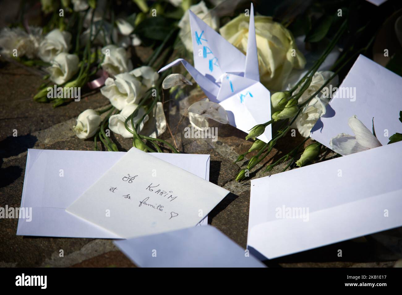 Un origami giapponese che simboleggia la pace e ha scritto 'Karim', vicino ad una busta che legge 'per Karim e la sua famiglia'. Mentre il governo di Macron rifiuta lo sbarco della barca Aquarius a Marsiglia, i 58 rifugiati che ha salvato tra Libia e Italia, la gente si è riunita nella Prefettura per rendere omaggio a Karim, un giovane rifugiato che la settimana scorsa ha commesso il suicidio in un centro di detenzione a Cornebarrieu vicino a Tolosa. Hanno messo fiori bianchi al centro del 'cerchio del silenzio'. Il 25th 2018 settembre, a Tolosa Francia. (Foto di Alain Pitton/NurPhoto) Foto Stock