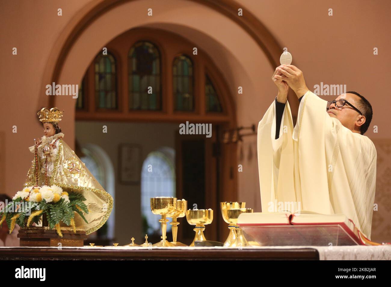 Il sacerdote cattolico filippino compie la comunione durante una speciale messa che celebra la festa di Santo Niño de Cebú a Toronto, Ontario, Canada. La devozione al Santo Niño, un'immagine di Gesù come un ragazzino tipicamente vestito da re, è un pilastro della vita cattolica filippina. (Foto di Creative Touch Imaging Ltd./NurPhoto) Foto Stock