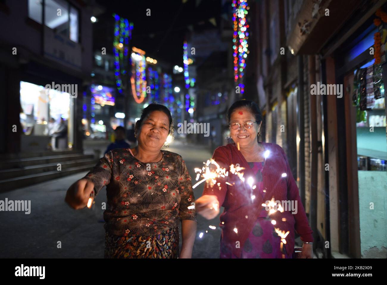 La donna nepalese sorride come tenendo bei sparklers (cracker di fuoco) nelle mani durante Laxmi Puja come la processione di Tihar o Deepawali e Diwali celebrazioni a Kathmandu, Nepal Mercoledì, 07 novembre 2018. Tihar è un festival indù celebrato in Nepal per 5 giorni. Le mucche sono considerate l'incarnazione del dio indù della ricchezza, Signore Laxmi. (Foto di Narayan Maharjan/NurPhoto) Foto Stock