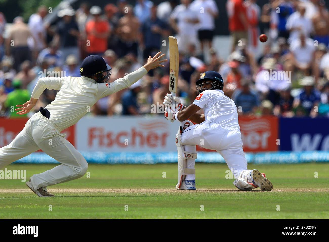 Inghilterra il cricket Rory Burns (L) si tuffa per catturare la palla mentre il capitano di cricket dello Sri Lanka Dinesh Chandimal guarda durante il gioco di 2nd giorni della prima partita di cricket di prova tra Sri Lanka e Inghilterra allo stadio di cricket internazionale di Galle, Galle, Sri Lanka, il 7 novembre 2018. (Foto di Tharaka Basnayaka/NurPhoto) Foto Stock