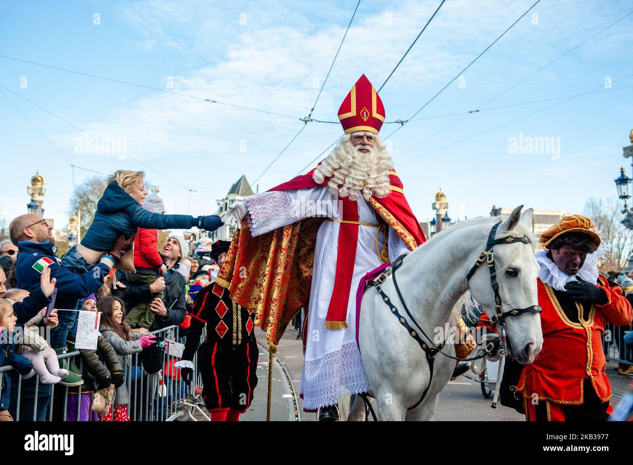 San Nicola, cavalcando il suo cavallo Amerigo il 18th 2018 novembre ad Amsterdam, Paesi Bassi. Con più di un chilometro di carri e barche, Amsterdam ospita la più grande sfilata di San Nicola del mondo. Sinterklaas naviga in città la domenica di metà novembre con 600 Pieten e un sacco di pepernoten (piccoli biscotti speziati), accolti da oltre 400.000 spettatori che fiancheggiano i canali. La leggenda beared bianca tradizionalmente fa il suo ingresso spettacolare nella città navigando lungo il fiume Amstel e seguendo un percorso attraverso la città passando il Nieuwe Amstelbrug, Torontobrug, il Hoge Sluis vicino al Foto Stock