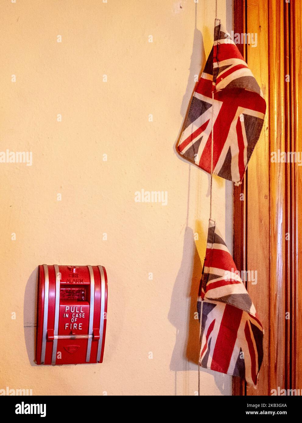 Union Jacks su un muro, allarme antincendio, 'tirare in caso di incendio'; Craigdarroch Castle, Victoria, B.C., Canada Foto Stock