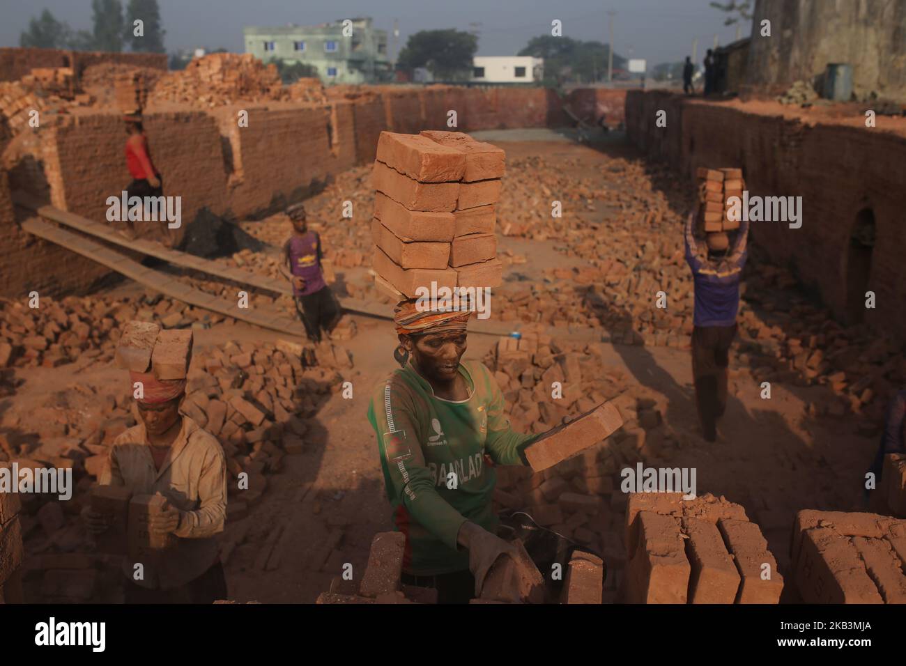 I lavoratori del Bangladesh lavorano in un campo di mattoni a Dhaka, Bangladesh, il 28 novembre 2018. I lavoratori lavorano nei campi di mattoni fino al crepuscolo con condizioni malsane in quanto il loro stipendio non soddisfa gli standard minimi. (Foto di Rehman Asad/NurPhoto) Foto Stock